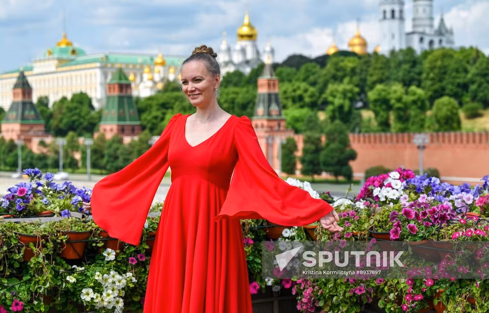 Женщина позирует на Большом Москворецком мосту, украшенном цветами в рамках фестиваля «Сады и Цветы» в Москве (Фото: Спутник)