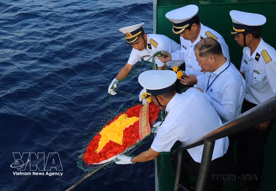 Офицеры и солдаты опускают в море венок в форме национального флага, почитая память павших героев, погибших в акватории Чыонгша (4 июня 2021 г.) (Фото: ВИА)