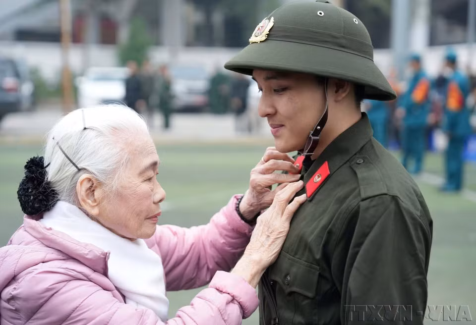 Нгуен Тхи Минь Тхуан (90 лет) провожает внука на службу в народной полиции на пункте приёма новобранцев в районе Донгда, Ханой (февраль 2025 года) (Фото: ВИА)