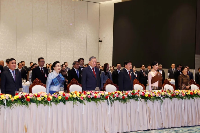 Генеральный секретарь То Лам и супруга, Генеральный секретарь Центрального комитета Народно-революционной партии Лаоса, Президент Лаосской Народно-Демократической Республики Тхонглун Сисулит и супруга вместе с делегатами проводят церемонию приветствия флага. 