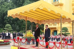 Генеральный секретарь То Лам и Первый секретарь, Президент Кубы Мигель Диас-Канель Бермудес стоят на почётном подиуме и слушают, как военный оркестр исполняет государственные гимны двух стран. (Фото: ВИА)