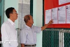 Избиратели знакомятся с краткой биографией кандидата в депутаты Народного совета общины Танхонг (Донгтхап) на срок полномочий 2026–2031 годов. (Фото: ВИА)