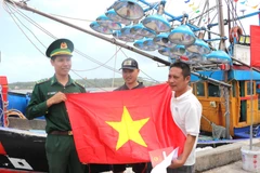 Вручение государственных флагов рыбакам. (Фото: ВИА)