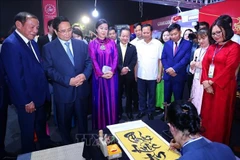 Премьер-министр Фам Минь Тьинь осматривает вьетнамское культурное пространство на Всемирном культурном фестивале. (Фото: ВИА)