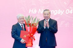 Генеральный секретарь То Лам вручает Решение Политбюро о распределении и назначении товарища До Ван Тьена на должность постоянного заместителя секретаря партийного комитета Национального собрания. (Фото: ВИА)