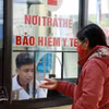 Житель провинции Лаокай регистрируется для прохождения медицинского осмотра и лечения по полису медицинского страхования в местном медицинском центре. (Фото: ВИА) 