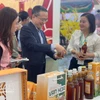 Главный представитель ханойского офиса JETRO Одзаса Харухико (в центре) посещает один из стендов на первой ярмарке «Славная весна» 6 февраля. (Фото: ВИА) 
