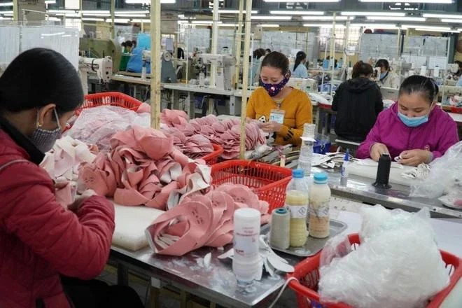 Один из этапов производства обуви на экспорт. (Фото: VietnamPlus) 3.png
