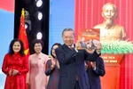 Генеральный секретарь То Лам с радостью принимает фотоальбом «Слава навеки принадлежит народу», торжественно вручённый Вьетнамским информационным агентством. Фото: ВИА.