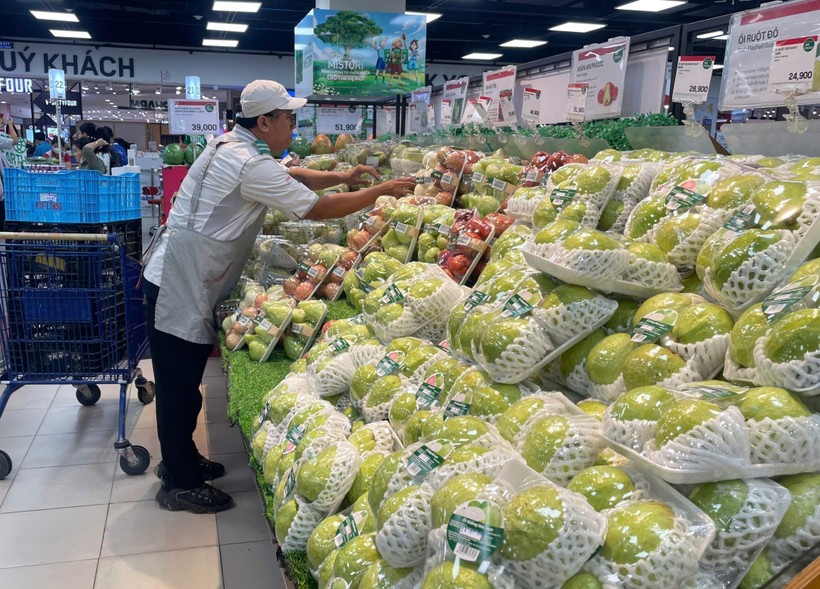 Сотрудник супермаркета Lotte Mart раскладывает фруктовую продукцию. Фото: ВИА.