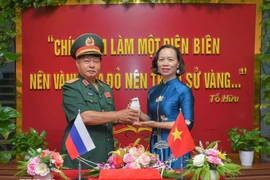 Генерал-майор Лыу Чонг Лы, председатель Ассоциации ветеранов провинции Дьенбьен, вручил капсулу со священной землей Ву Тхи Тует Нга, директору Музея Победы при Дьенбьенфу (Фото: ВИА)