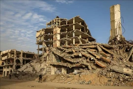 Жители идут рядом с завалами разрушенных в результате конфликта зданий в городе Газа (Фото: Синьхуа/ВИА)