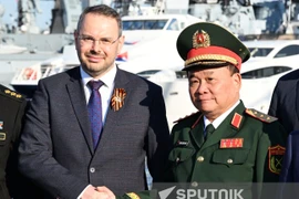 Заместитель министра науки и высшего образования РФ Константин Могилевский и заместитель министра обороны Вьетнама генерал-полковник Хоанг Суан Тьен пожимают друг другу руки и позируют для фото во время церемонии передачи (Фото: Спутник)