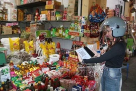 Покупатель осуществляет оплату по безналичному расчёту, сканируя QR-код на рынке Киба (квартал Чанлам, провинция Хынгйен) (Фото: ВИА)