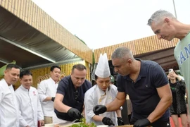 Иностранные туристы пробуют приготовить салат из сырой рыбы на фестивале "Da Nang Food Tour 2025"