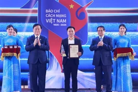 Премьер-министр Фам Минь Тьинь и глава Отдела ЦК КПВ по пропаганде, политическому воспитанию и массовой мовилизацийи Нгуен Чонг Нгиа вручили награду представителю группы авторов электронной газеты VietnamPlus (Ассоциация журналистов ВИА) (Фото: ВИА)