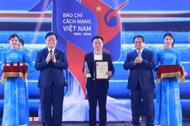 Премьер-министр Фам Минь Тьинь и глава Отдела ЦК КПВ по пропаганде, политическому воспитанию и массовой мовилизацийи Нгуен Чонг Нгиа вручили награду представителю группы авторов электронной газеты VietnamPlus (Ассоциация журналистов ВИА) (Фото: ВИА)
