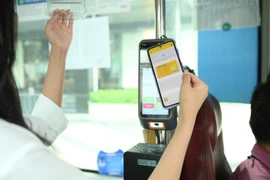 Оплата бесконтактным способом с помощью карты NAPAS в автобусной сети (Фото: nhandan.vn)