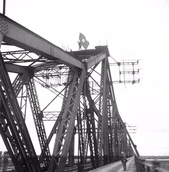 Солдаты поднимают флаг освобождения на вершине моста Лонгбьен. (Фото: Файл - ВИА)