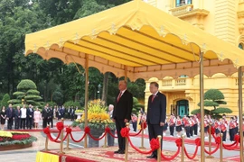 Генеральный секретарь То Лам и Первый секретарь, Президент Кубы Мигель Диас-Канель Бермудес стоят на почётном подиуме и слушают, как военный оркестр исполняет государственные гимны двух стран. (Фото: ВИА)