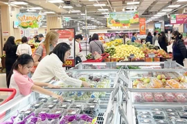 Покупатели выбирают фрукты в торговом центре Lotte Mall West Lake Hanoi. (Фото: Hanoimoi)