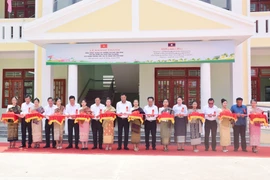 Делегации двух стран перерезают ленточку на церемонии открытия начальной и средней школы дружбы Ассоциации вьетнамцев провинции Салаван. (Фото: ВИА)