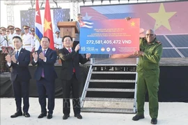 Заместитель Премьер-министра Хо Куок Зунг передаёт символический чек Вице-президенту Республики Куба Сальвадору Вальдесу Месе — сумму второго транша программы пожертвований в поддержку народа Кубы «65 лет солидарности Вьетнама и Кубы», организованной Обществом Красного Креста Вьетнама. (Фото: ВИА)