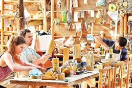 Туристы самостоятельно изготавливают сувениры из бамбука в одном из ремесленных предприятий в Дананге. (Фото: nhandan.vn)