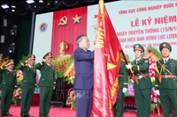 Генеральный секретарь То Лам прикрепил звезду Героя народных вооружённых сил к Знамени Победы Главного управления оборонной промышленности. (Фото: ВИА)