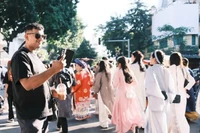 Туристы запечатлевают момент во время парада праздника вьетнамского традиционного костюма «Việt phục», проходящего в Ханое 15 ноября. (Фото: sggp.org.vn)