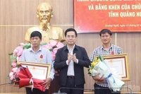 Председатель Народного комитета провинции Куангнгай Нгуен Хоанг Жанг вручает Орден Мужества Президента государства двум жителям Лишона. (Фото: ВИА)