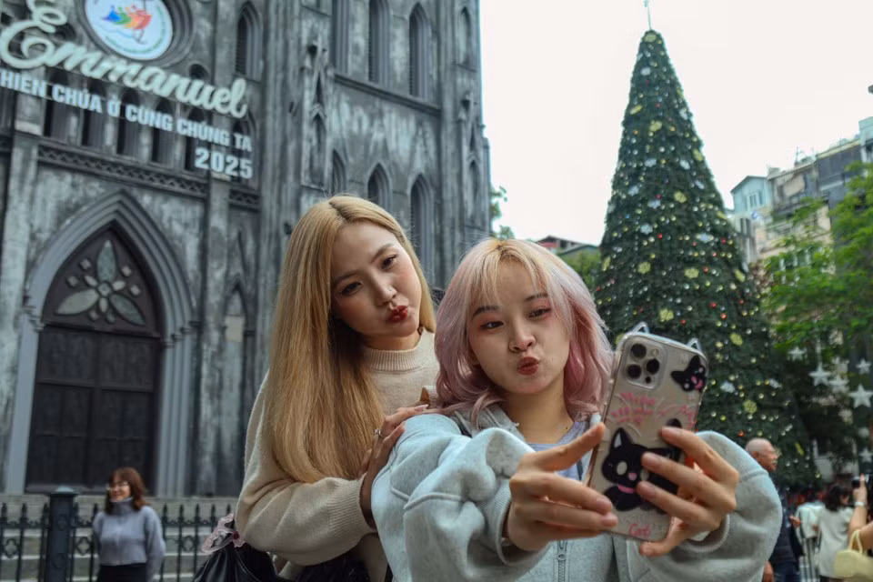 Многие молодые люди с удовольствием приходят, фотографируются у Кафедральный собор и делятся восторженными эмоциями и радостью, погружаясь в рождественскую атмосферу, охватывающую всю столицу. (Фото: Нят Минь / Vietnam+)