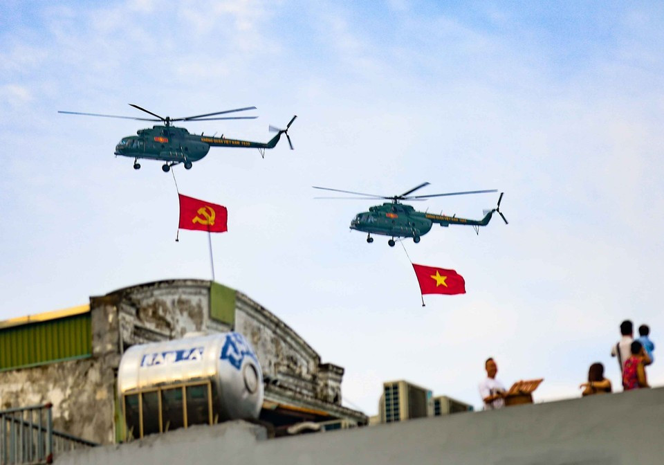Группа вертолетов Ми-171, Ми-17 и Ми-8 с партийным и государственным флагами пролетает над площадью Бадинь. (Фото: ВИA)