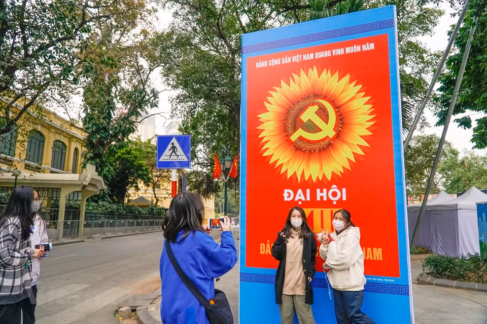 Молодежь позируется у красивых плакатов. (Фото: Минь Хиеу/Vietnam+)