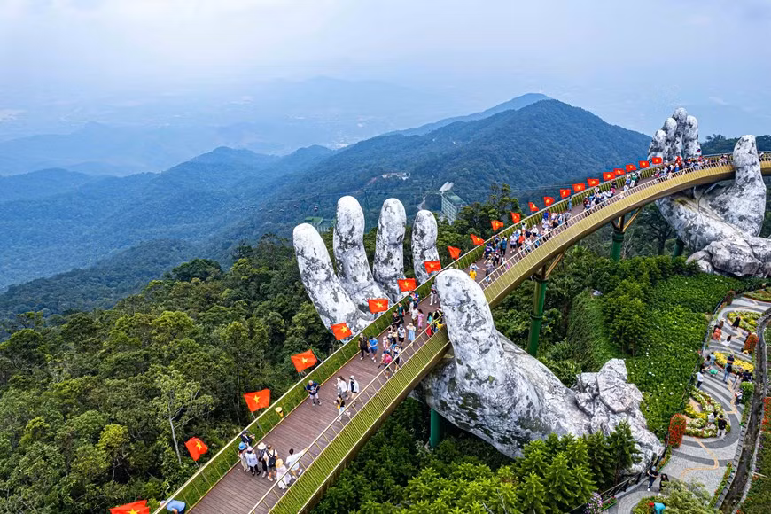 В этом году в честь Национального дня туристическая зона Sun World Ba Na Hills была украшена сотней красных флагов и золотых звезд вдоль Золотого моста общей длиной 148,6 метра. (Фото: ВИА)