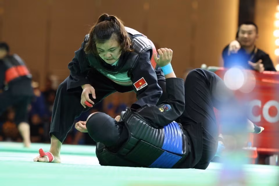 Спортсменка Куанг Тхи Тху Нгиа (красный пояс, справа) победила спортсменку Ниа Ларасати (Индонезия, синий пояс) в финале тяжелой атлетики в весовой категории 65-70 кг и принесла домой третью золотую медаль вьетнамской команде Pencak Silat. (Фото: ВИА)