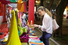 Иностранные туристы посещают и знакомятся с продукцией на Фестивале туристических сувениров Ханоя 2025 года. Фото: ВИА.