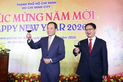 Чан Лыу Куанг (слева), член Политбюро, секретарь Городского партийного комитета города Хошимин, приглашает гостей поднять бокалы в честь Нового года. Фото: ВИА.