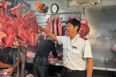 Сотрудник 9-й группы по контролю за безопасностью пищевых продуктов проводит органолептическую проверку свинины на прилавке. Фото: ВИА.