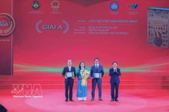 Заведующий Отделом ЦК КПВ по пропаганде, политическому воспитанию и работе с народными массами Чинь Ван Кует вручает премию А авторам и авторским коллективам — лауреатам премии. Фото: ВИА.