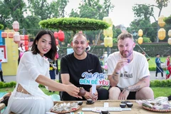 Иностранные туристы знакомятся с традицией дегустации чая с ароматом лотоса Западного озера. Фото: ВИА.