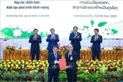 Премьер-министр Фам Минь Тьинь и Премьер-министр Лаоса Сонесай Сипхандон присутствуют при обмене документами о сотрудничестве между предприятиями двух стран. (Фото: ВИА).