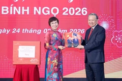 Генеральный директор ВИА Ву Вьет Чанг вручила Генеральному секретарю То Ламу фотоальбом, подготовленный журналистами Фоторедакции. Фото: ВИА.