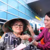 Представитель компании Anex Tour Vietnam вручает коническую шляпу первым пассажирам, прибывшим в Дананг из Владивостока. Фото: ВИА