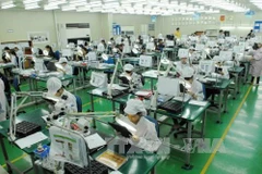 Рабочие компании Flexcom Vietnam, расположенной в индустриальном парке Йенфон в Бакнине (Фото: ВИА)