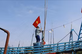 Рыбаки поднимают Государственный флаг перед выходом в море, подтверждая суверенитет страны над морскими и островными территориями.