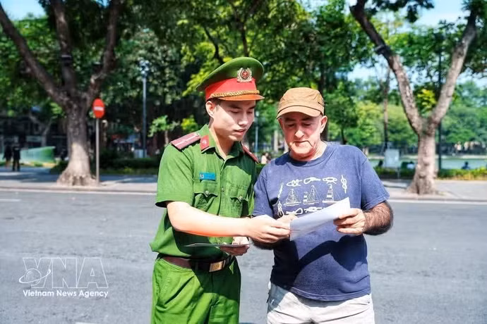 Сотрудник полиции знакомит иностранного туриста с киоском «Умный полицейский пункт», облегчая иностранным гостям доступ к услугам полиции. Фото: ВИА 