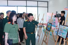 Участники мероприятия осматривают фотовыставку, посвящённую деятельности по предотвращению минной опасности во Вьетнаме. Фото: ВИА