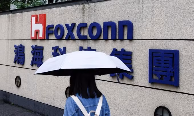 Женщина с зонтиком проходит мимо логотипа Foxconn у здания компании в Тайбэе, Тайвань, 31 октября 2022 года. (Фото: Reuters)