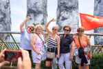 Иностранные туристы с удовольствием делают фото на фоне Золотого моста, украшенного яркими национальными флагами, в туристической зоне. (Фото: ВИА)